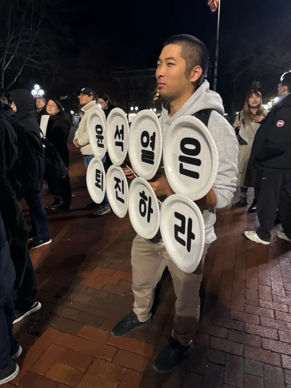 Awkwardly holding a banner that reads "Yoon Suk Yeol must step down", December 2024.