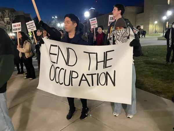 Holding a banner that reads "End the occupation" at a pro-Palestine rally; I believe January 2024.